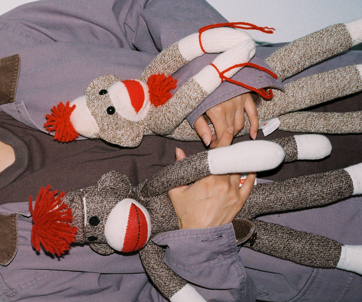 Close-up of two retro sock monkeys held against a jacket