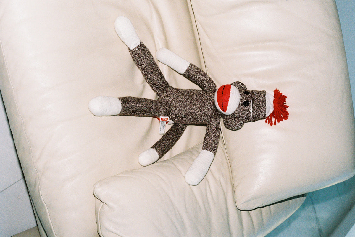 Retro sock monkey on a cream sofa